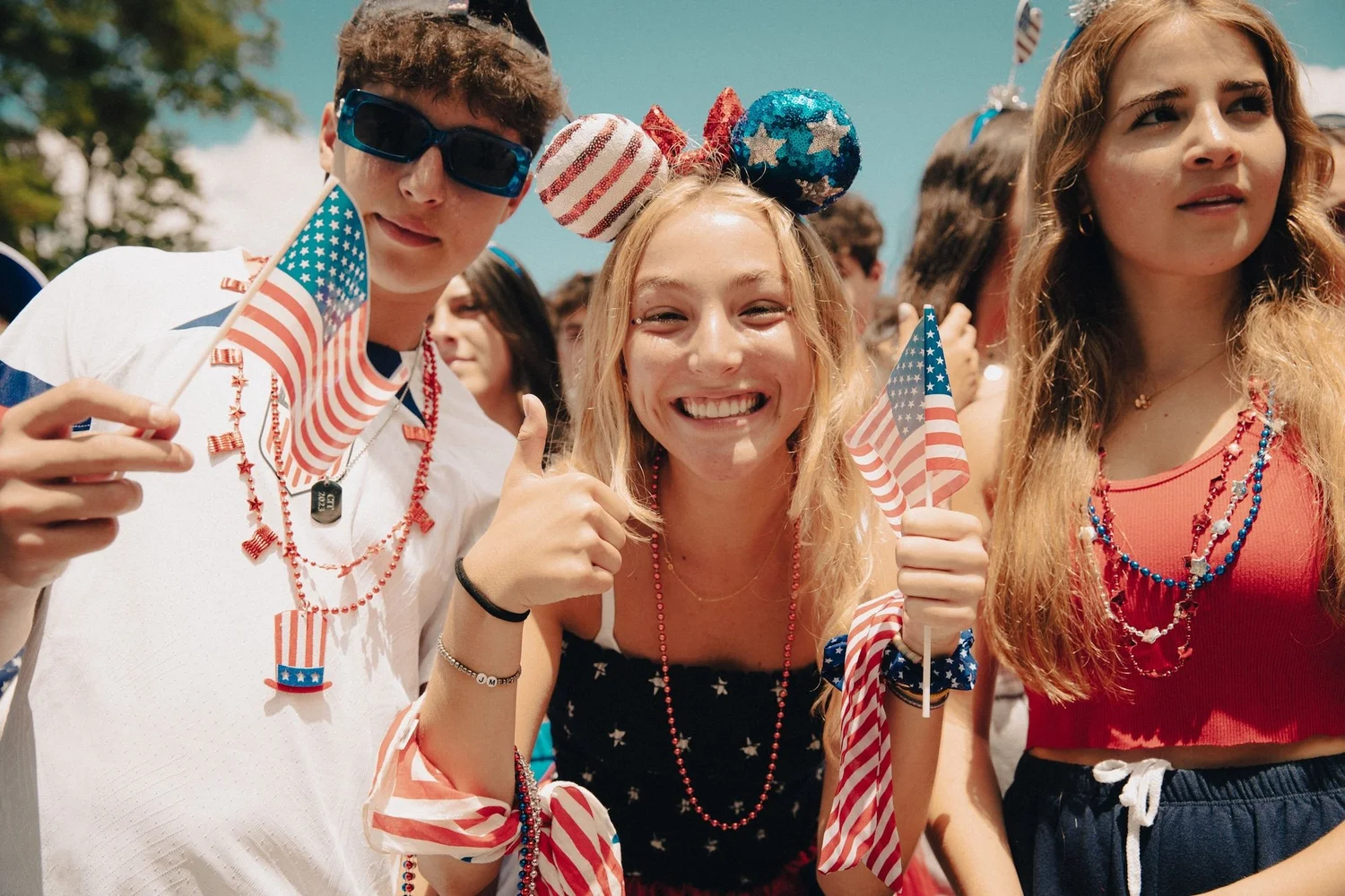 Betreuer des IHC-Camps posieren für ein Foto und tragen Accessoires mit der amerikanischen Flagge