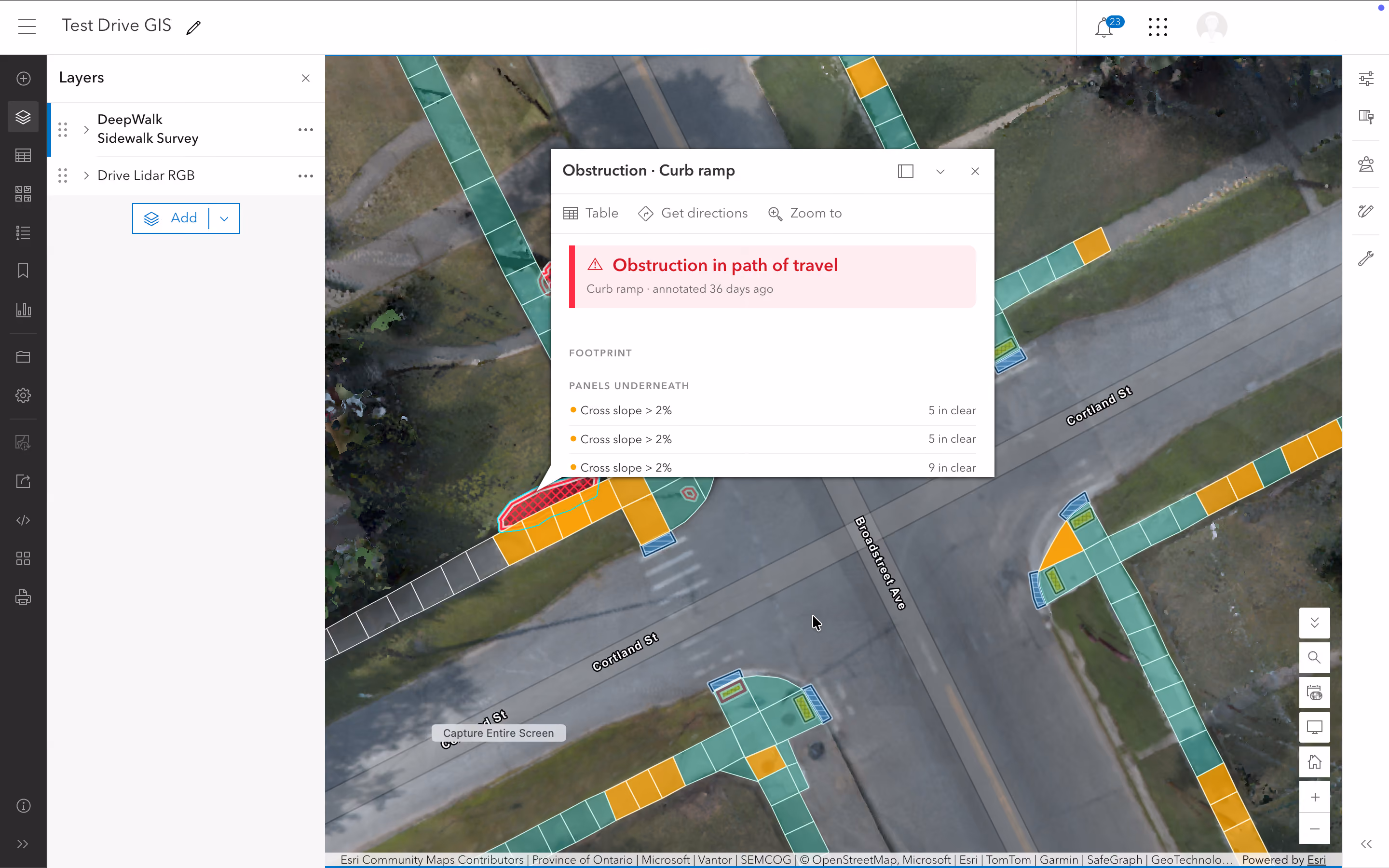 Screenshot of a GIS map interface titled Test Drive GIS showing mapped curb ramps and sidewalks at an intersection with colored segments indicating survey data; a popup highlights an 'Obstruction in path of travel' on a curb ramp with details on cross slope panels underneath.