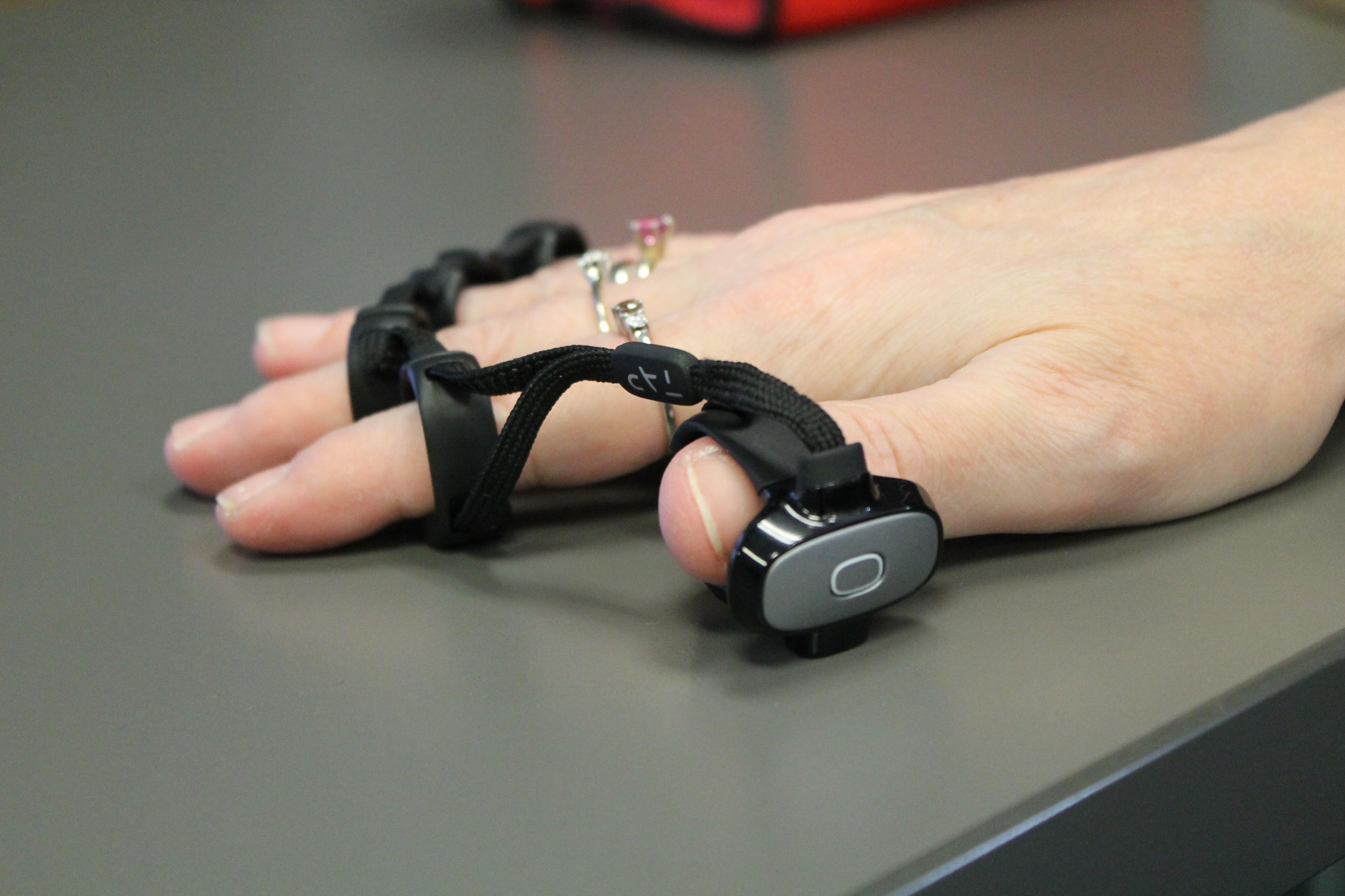 A Person's Hand with a Wrist Strap Touch Device Attached to It.