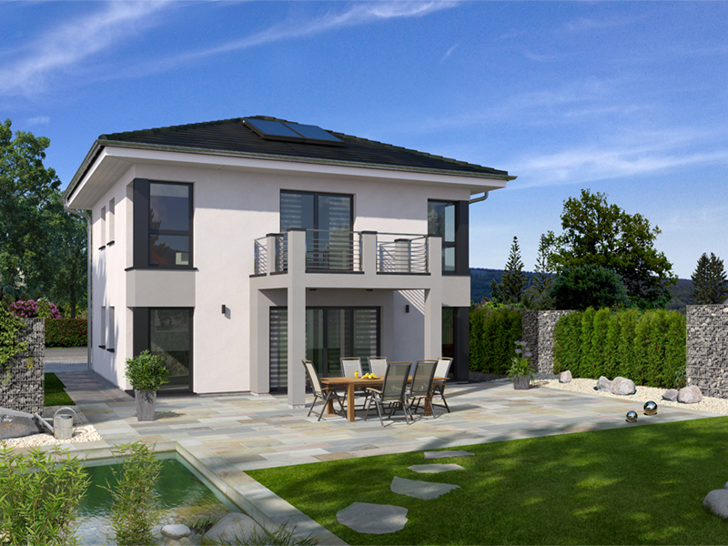 Modern two-story white house with large windows, a balcony, and an outdoor patio with dining table and chairs overlooking a green lawn and stone pathway.