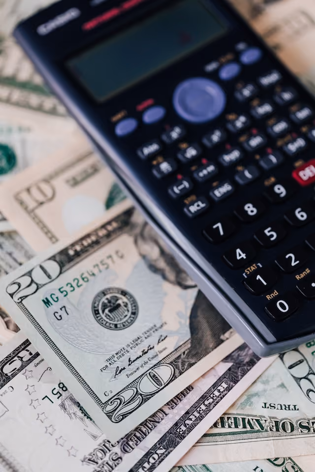 A calculator and dollar bills