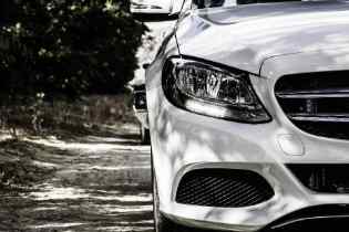 close up of the front of half of a mercedes showing the headlight and part of the grill
