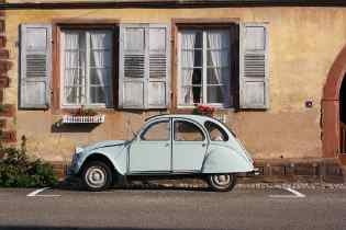 side view of an old fiat 500 parked in parallel on the side of the road