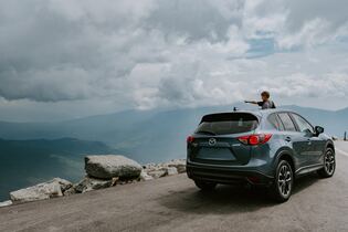 mazda on a mountain road stopped overlooking a lake