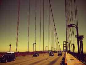 cars a a large suspension style bridge at dusk