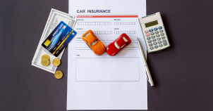 A man protecting his red toy car with cheap insurance with an extended warranty.