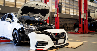 Mechanic using a ratchet wrench to repair a car engine at an auto shop in the USA