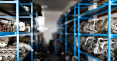 Mechanic inspecting and repairing a car clutch system inside an auto repair shop.
