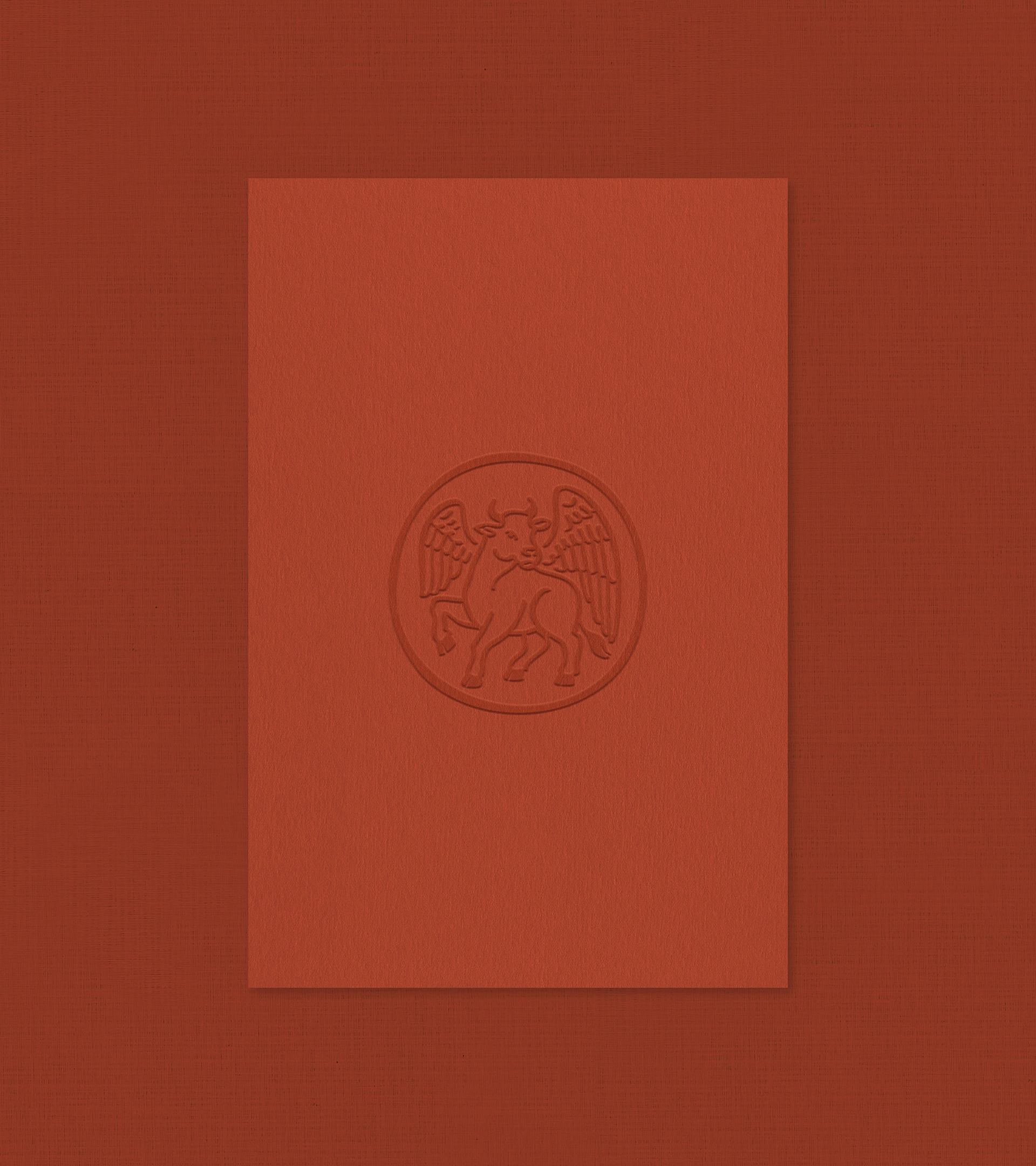 Logo Villa Luka en relief sur une carte en papier texturé couleur terre cuite, présentant un motif subtil en relief représentant un taureau ailé