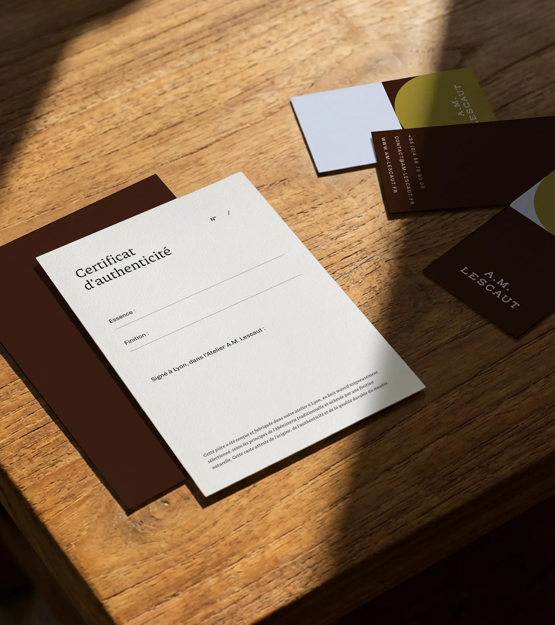 Certificat d'authenticité et cartes de visite d'A.M. Lescaut présentés sur une table en bois.