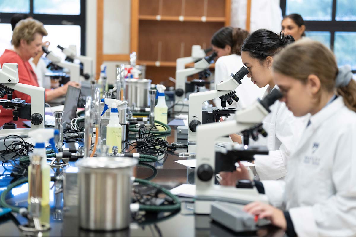 Students looking in microscopes in biology class