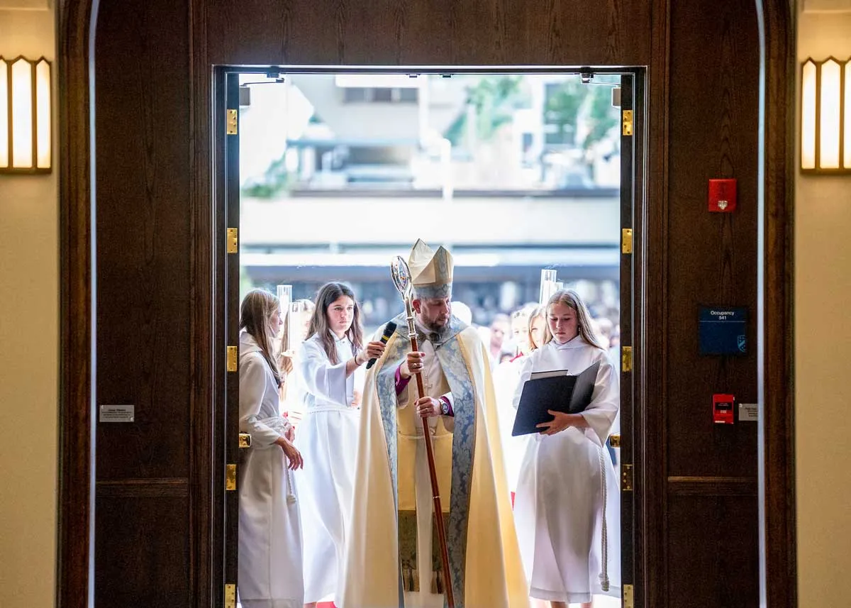 The Bishop leads in the congregation through the front doors during the consecration of the Berkeley Chapel
