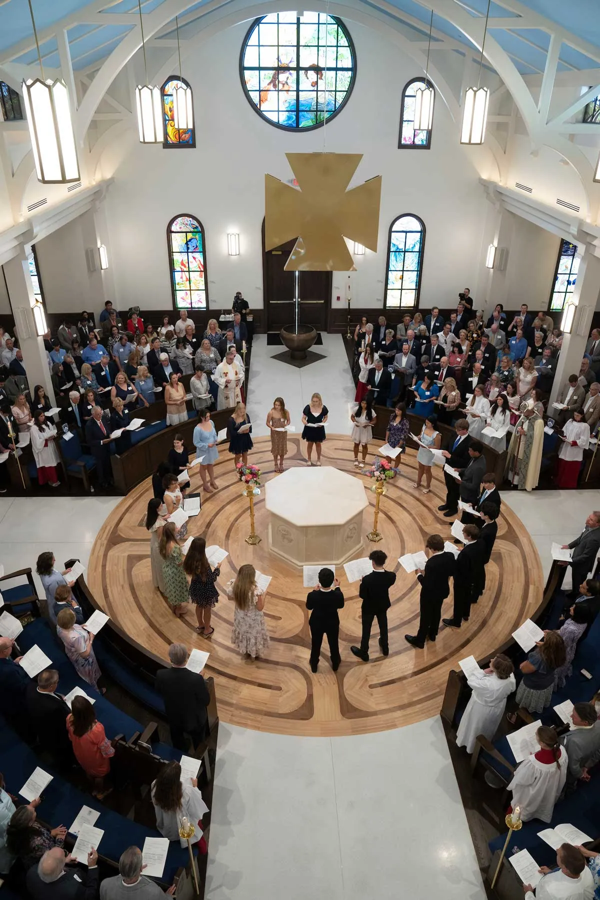 Student singers standing in a circle around the alter during the consecration of the Berkeley Chapel