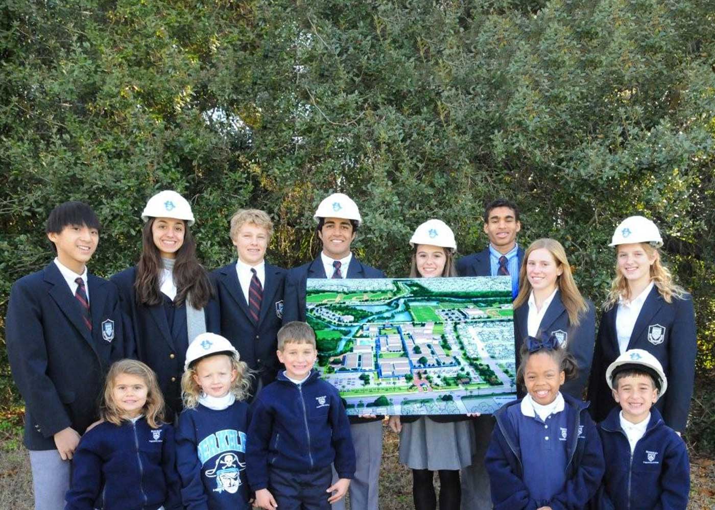 Group of students holding up a rendering of the master plan designs in 2008