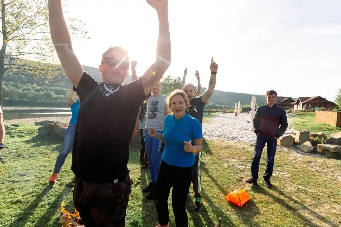 Noltic team cheering with raised arms during an outdoor team-building game