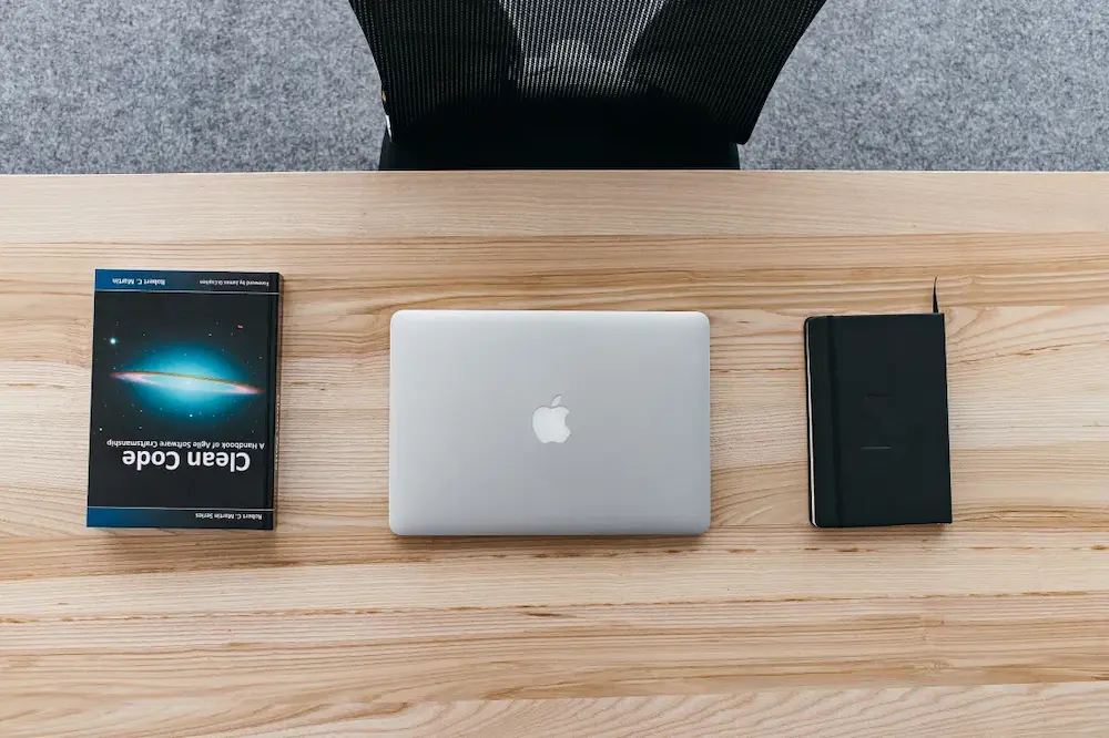 A laptop computer sitting on top of a wooden table.