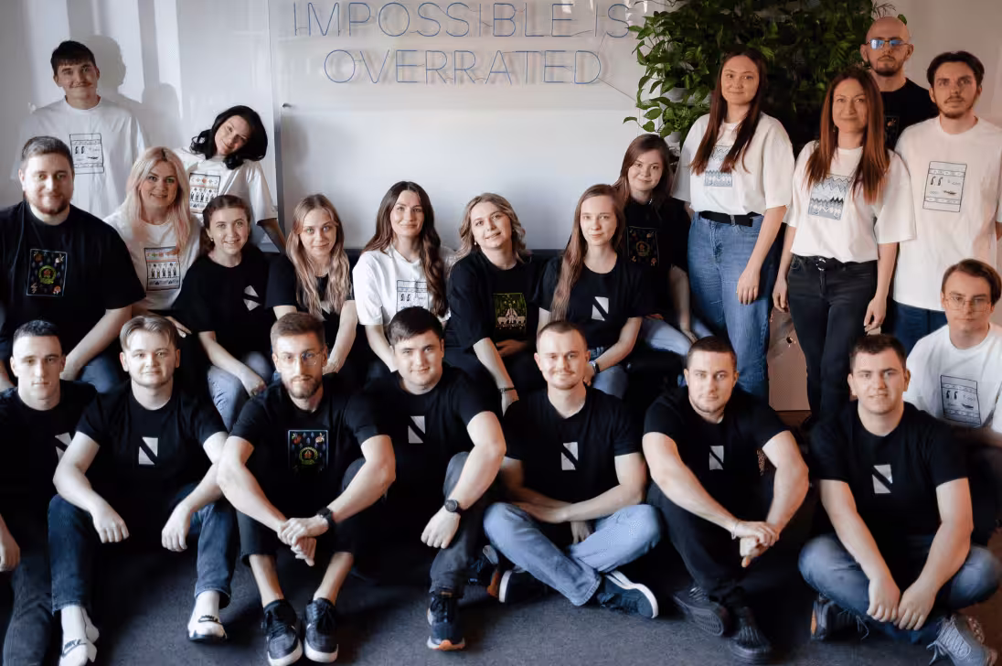 Group of diverse people posing indoors under a sign that reads impossible is overrated.
