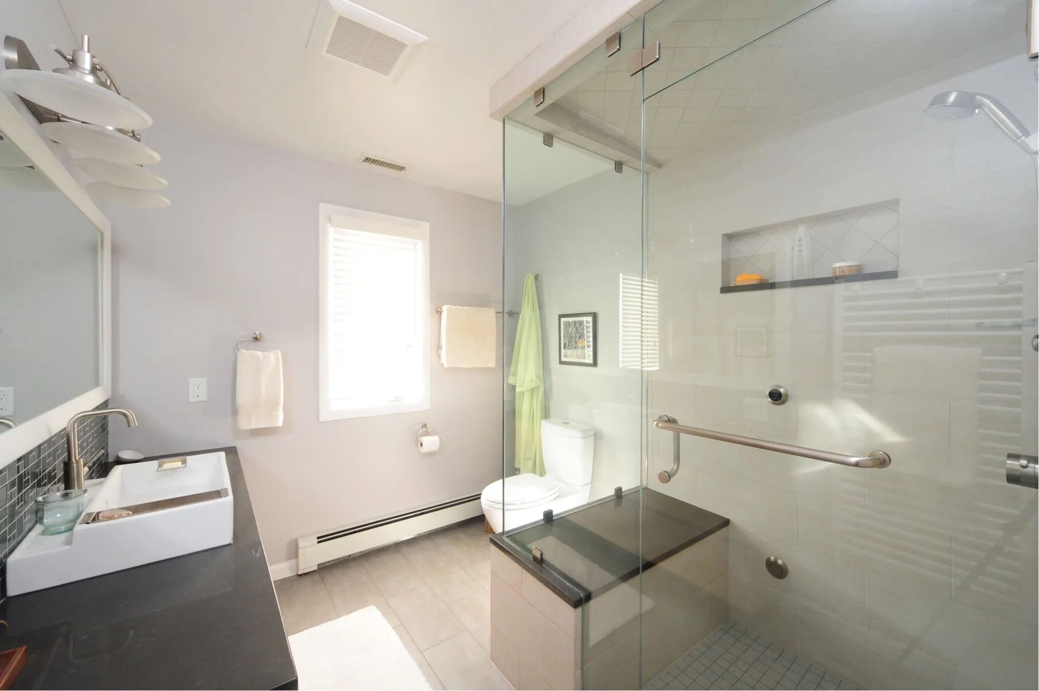 A renovated bathroom. New glass shower, basin, and toilet