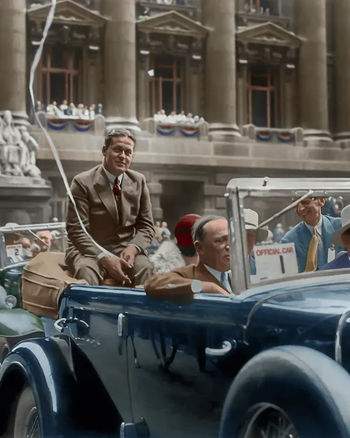 A man sitting in the back of an old car.