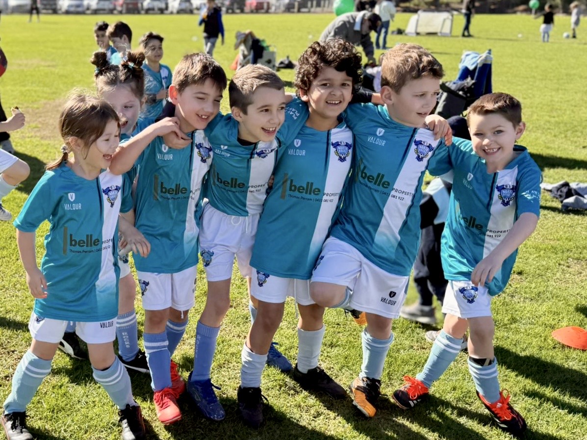 A team of soccer players smiling for photo