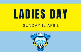 Youth soccer team posing together on grass field with some players wearing yellow pinnies.