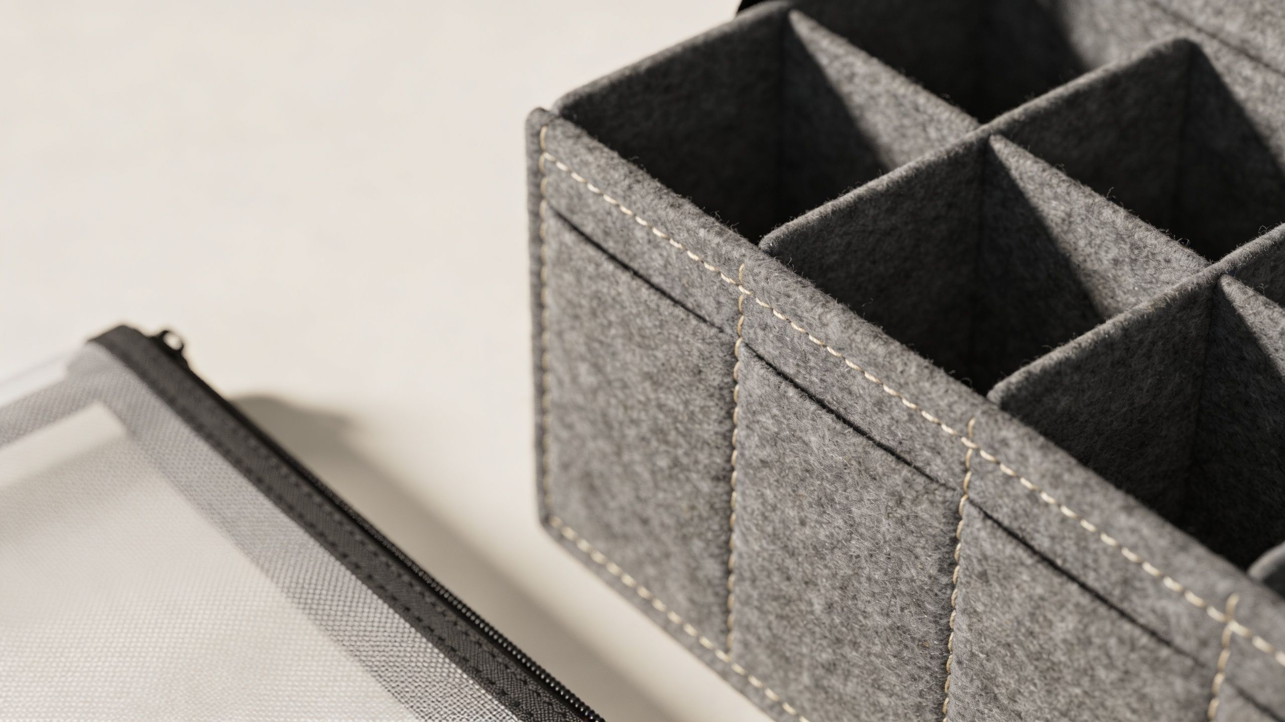 A gray felt bag in bag organizer with multiple compartments resting on a white surface.
