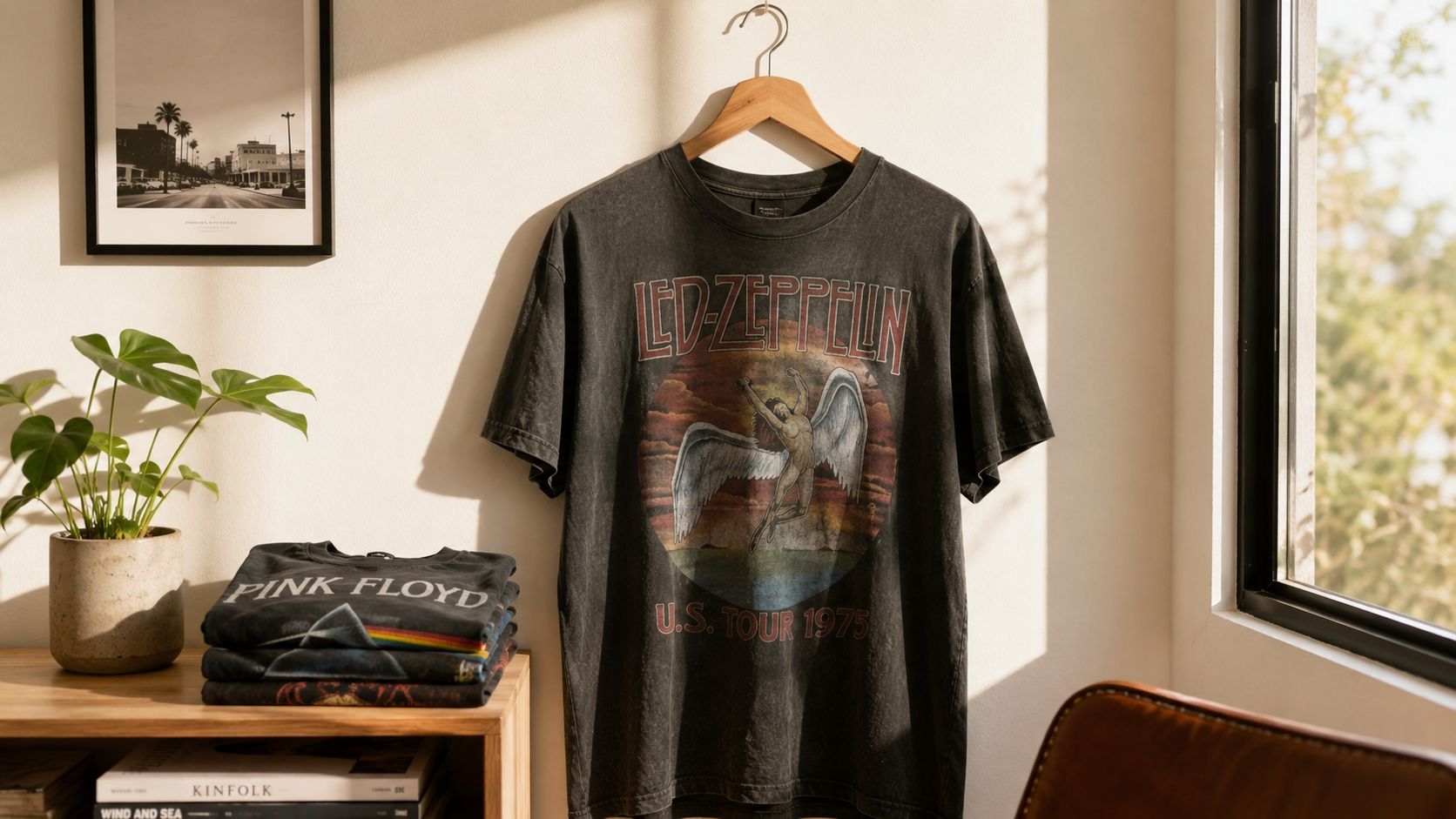 A hanging vintage-style Led Zeppelin concert t-shirt displayed next to a stack of folded band shirts.