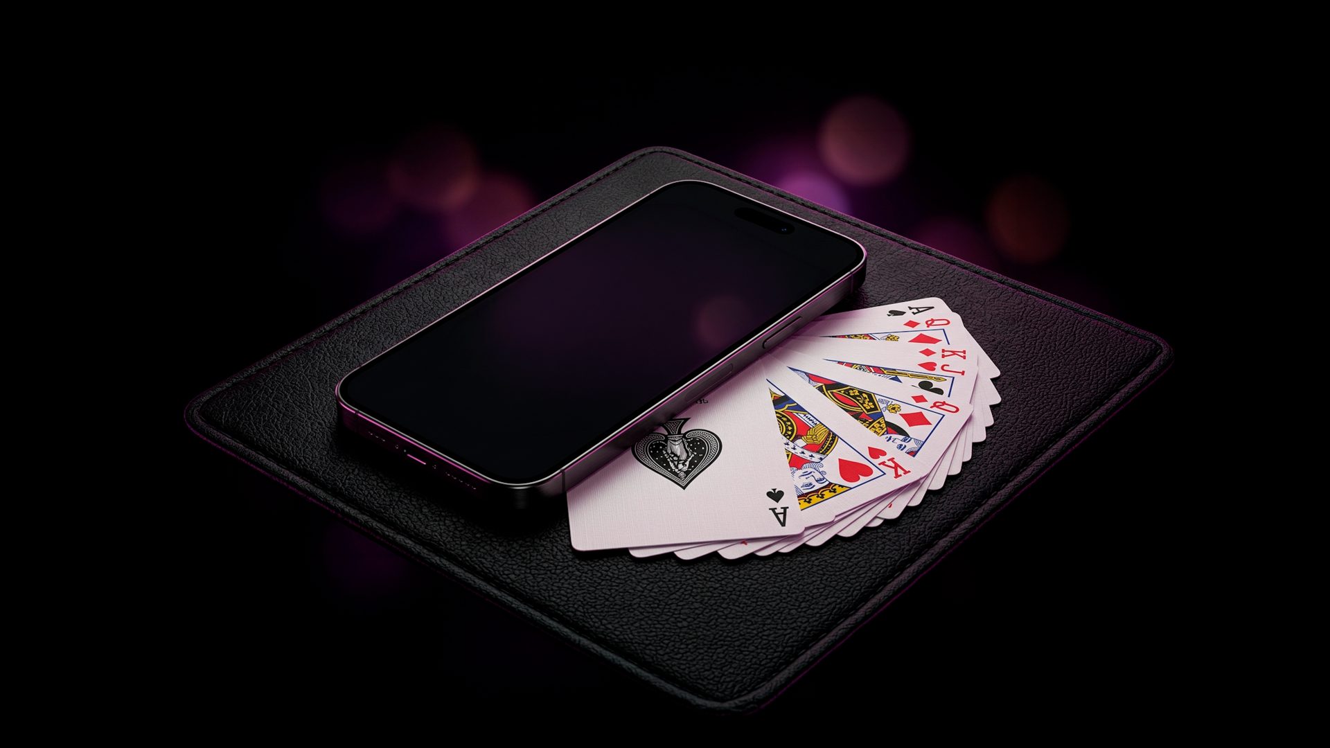 iPhone posé sur un tapis de cartes à côté d'un éventail de cartes à jouer