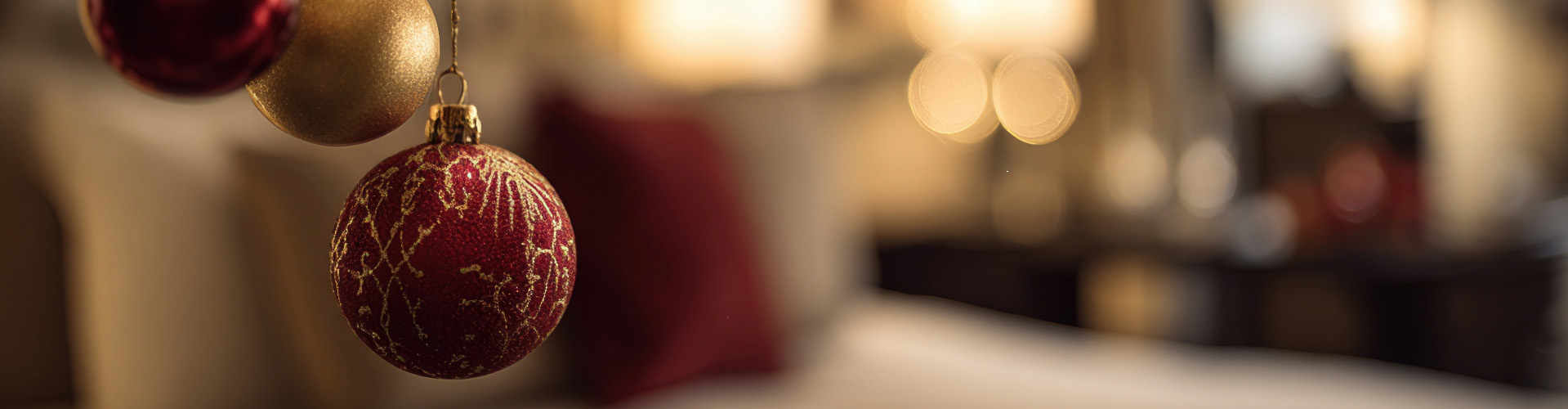 Gold and red Christmas baubles hanging with bokeh lights at The Esplanade Hotel Llandudno.