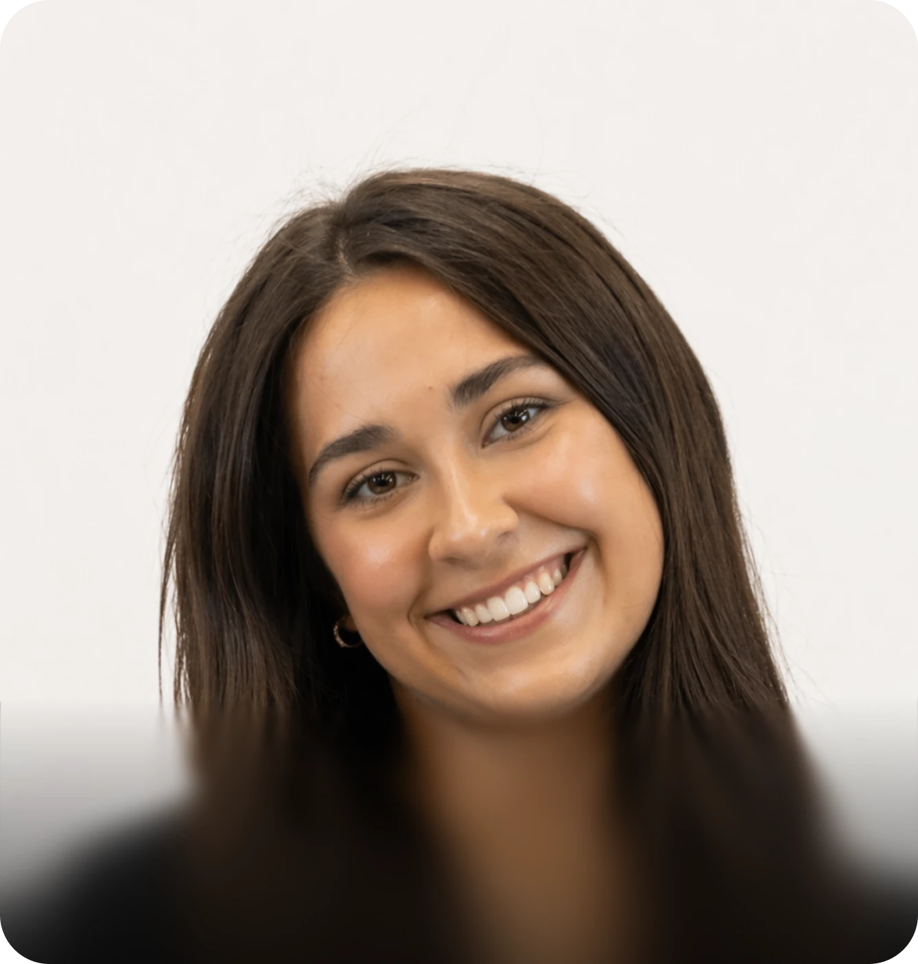 Professional headshot of a smiling woman with long brown hair against a plain white background.