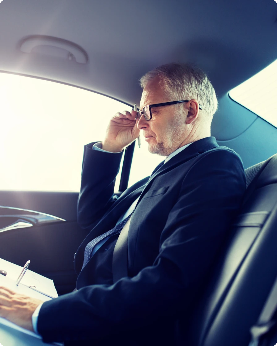 Executive reviewing documents in the back seat of a Savoya chauffeured vehicle