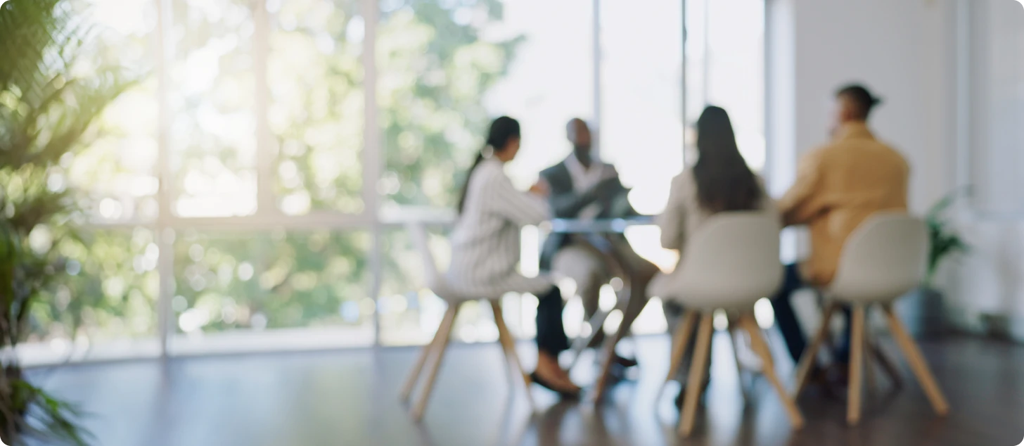 Savoya team members meeting around a table in a bright office