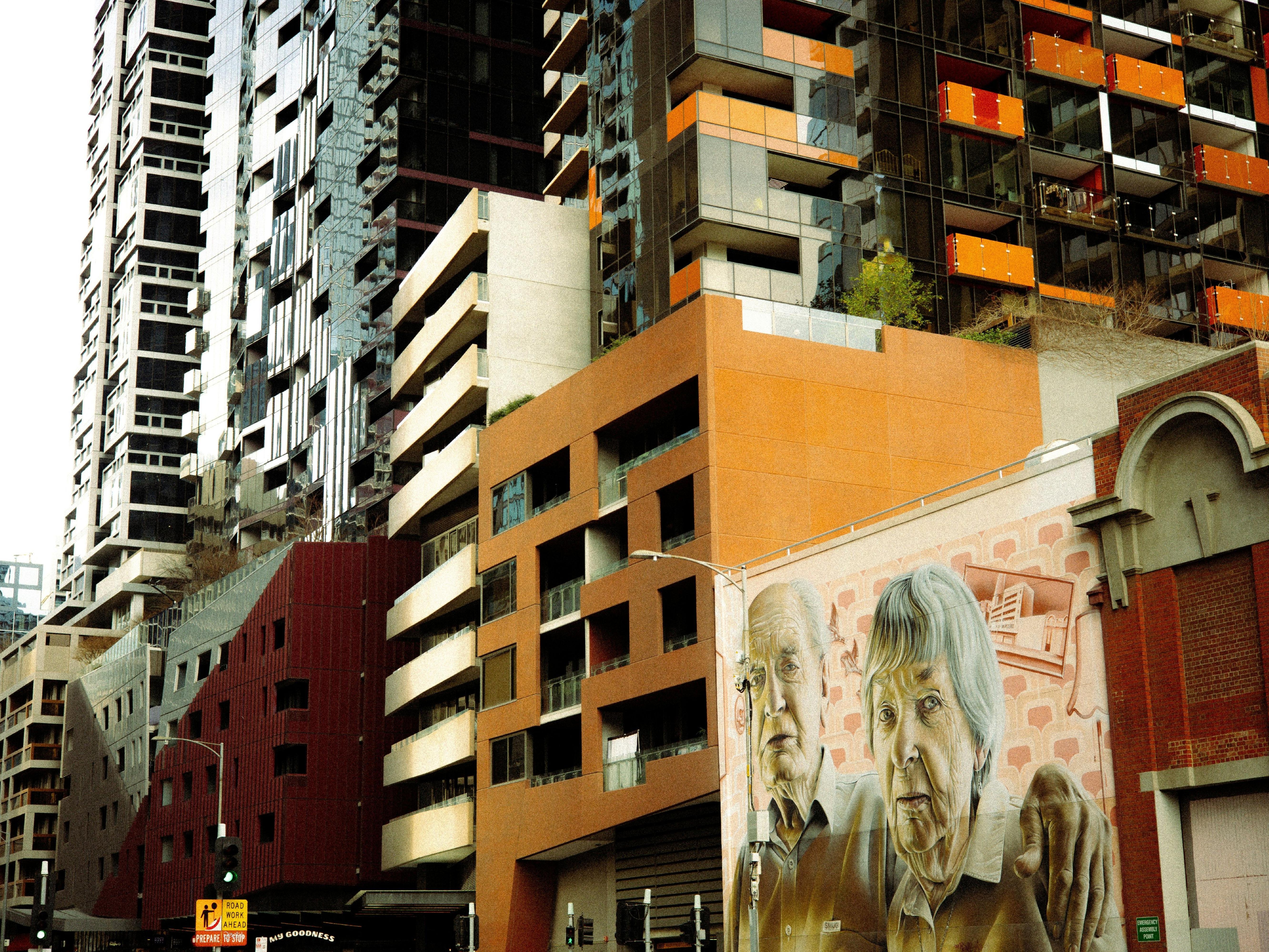 Street view of apartment buildings with mural of old couple