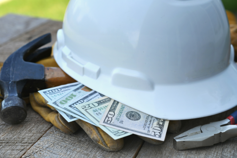 Two people collaborating over laptops and handwritten notes on a wooden desk.