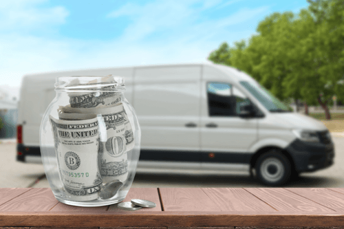 Two chefs in striped aprons preparing trays of food in a professional kitchen.