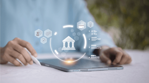 Smiling woman in light gray apron holding a wooden sign that says 'WELCOME WE ARE OPEN' in front of a weathered blue door.