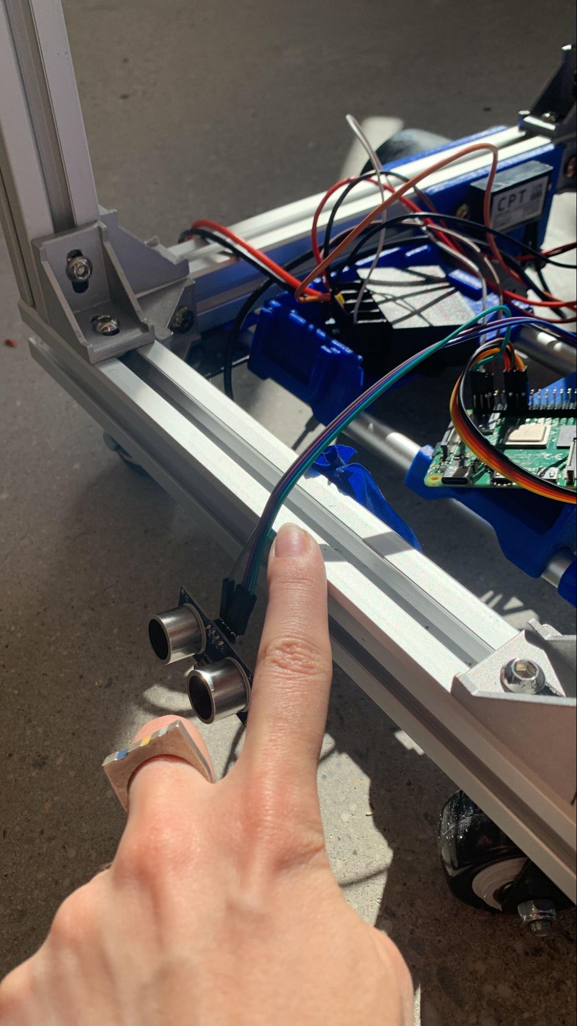 A finger pointing to the placement of where the ultrasonic sensor would live within the rover base.