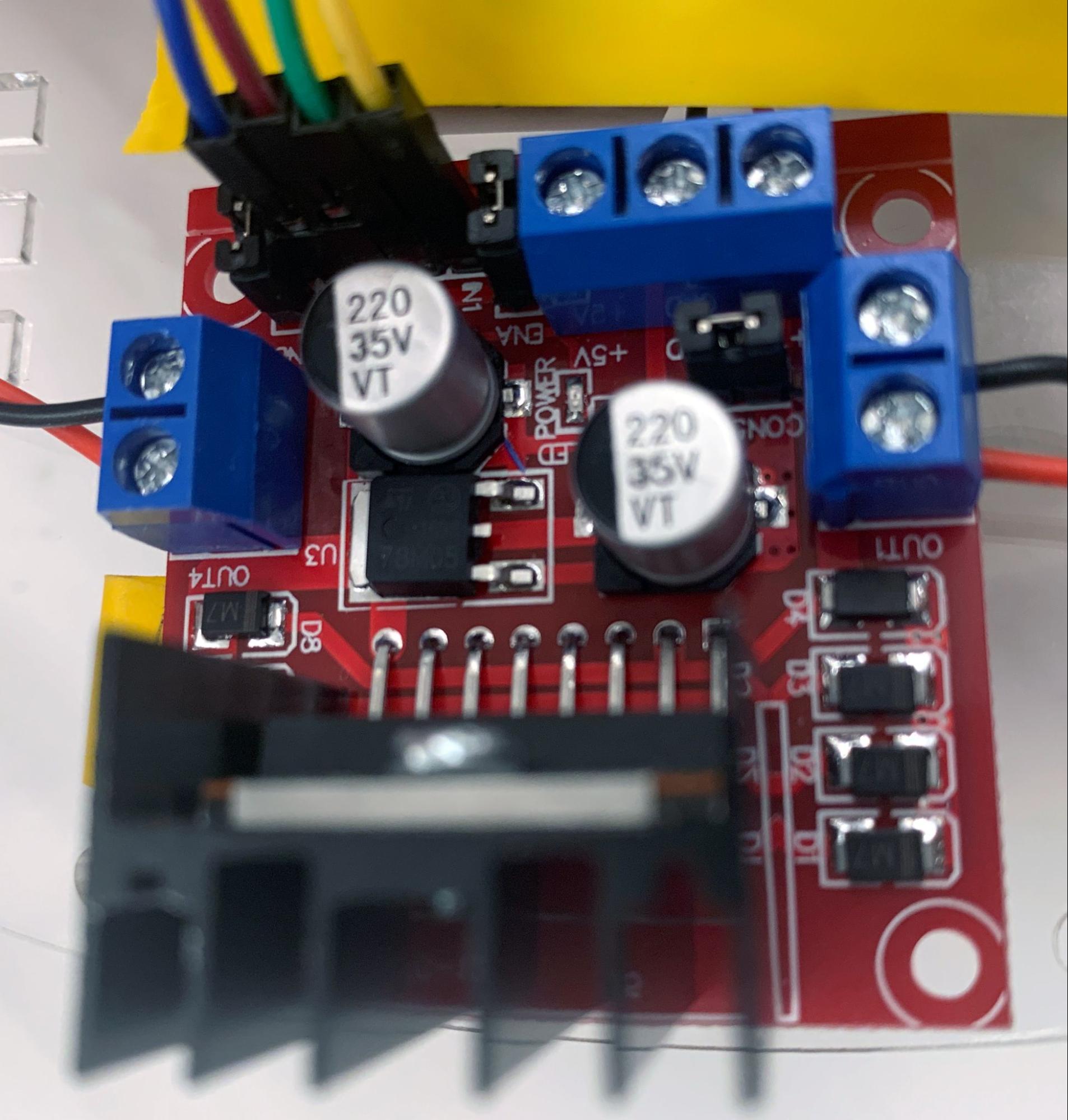 Dual H-bridge motor controller with four signal wires going in and two sets of motor power wires coming out.