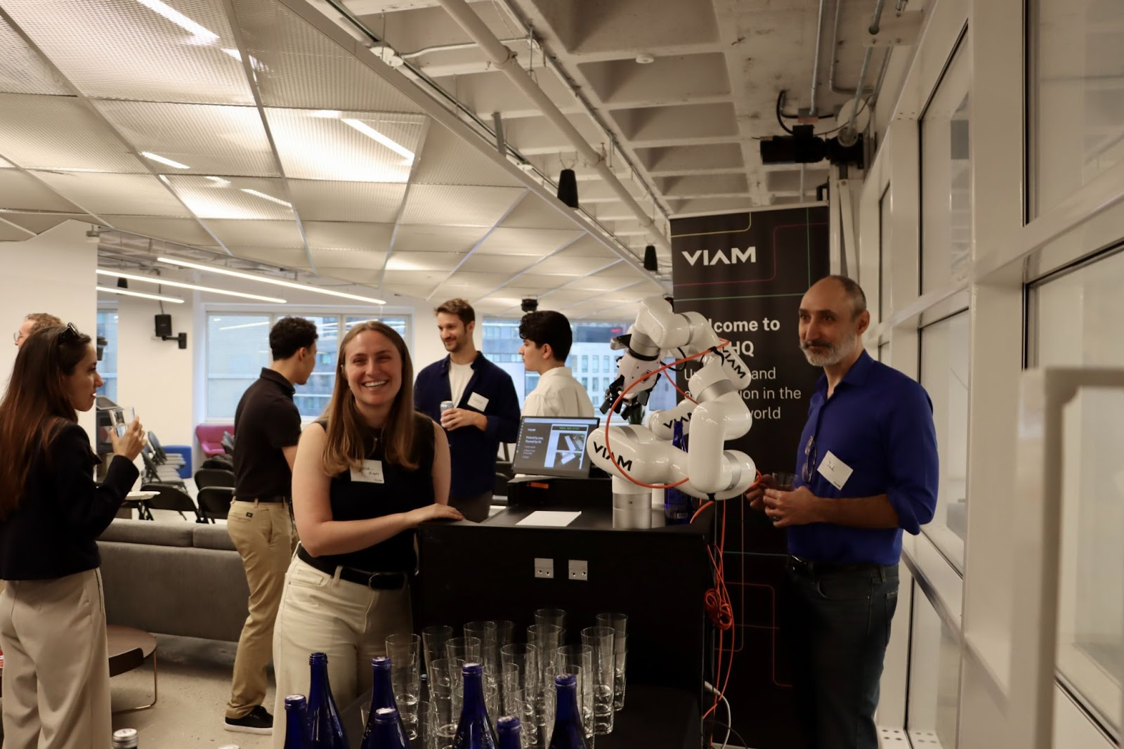 Viam team members posing with a water-pouring robot