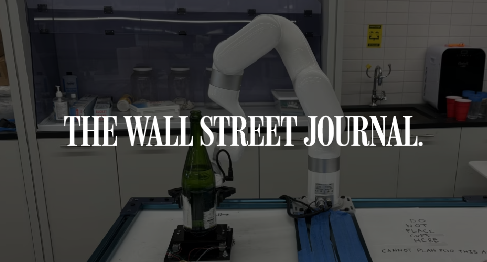 An image of a robotic arm holding a bottle of wine in the Viam lab with the Wall Street Journal logo over it