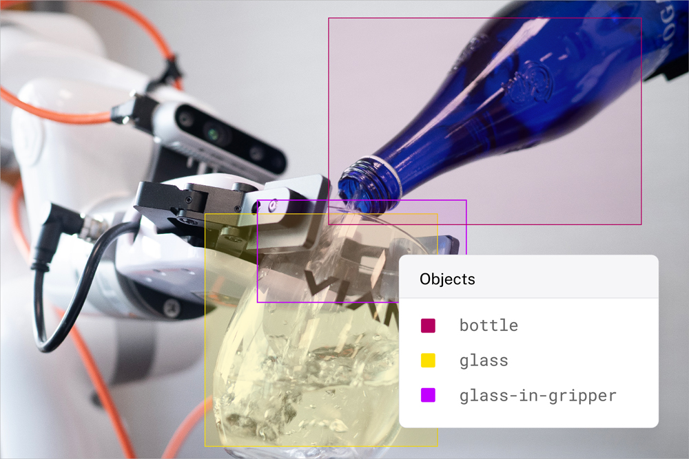 An image showing a robotic arm holding a glass while another arm holds a bottle of water and pours it into the glass. The image has bounding boxes showing how you can train viam to detect objects in the photo. 