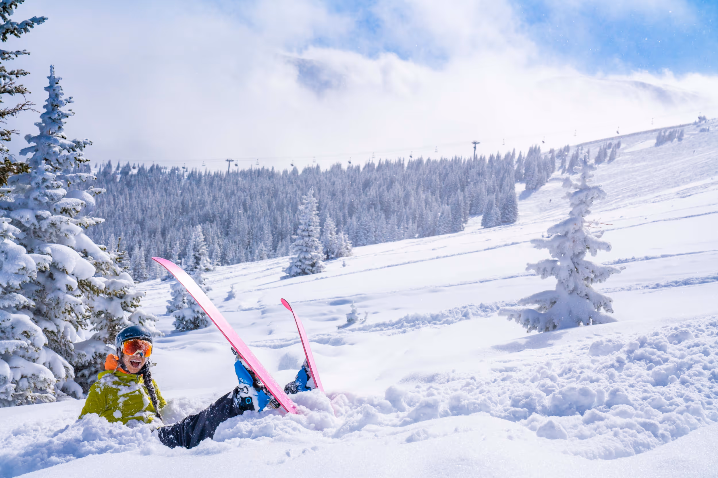 A skier laughing off a fall in some deep POW
