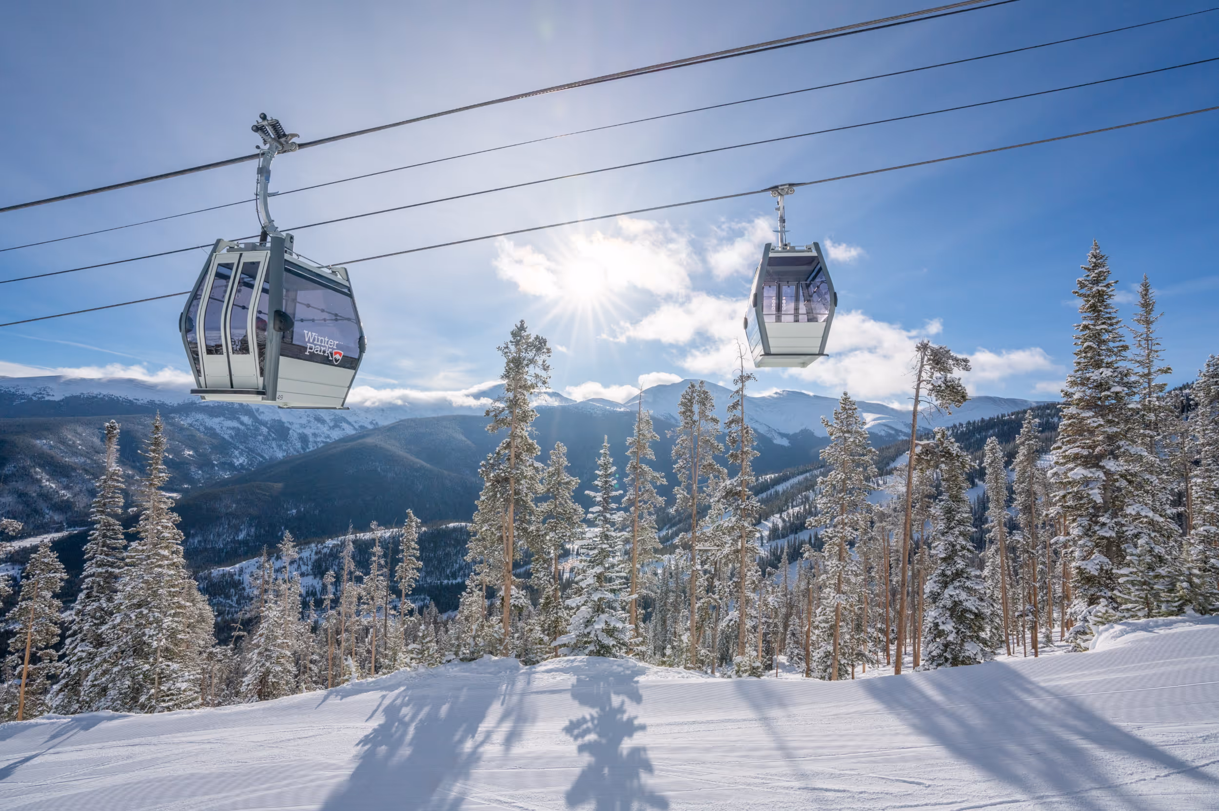 The gondola casting shadows on the groomers of Winter Park 