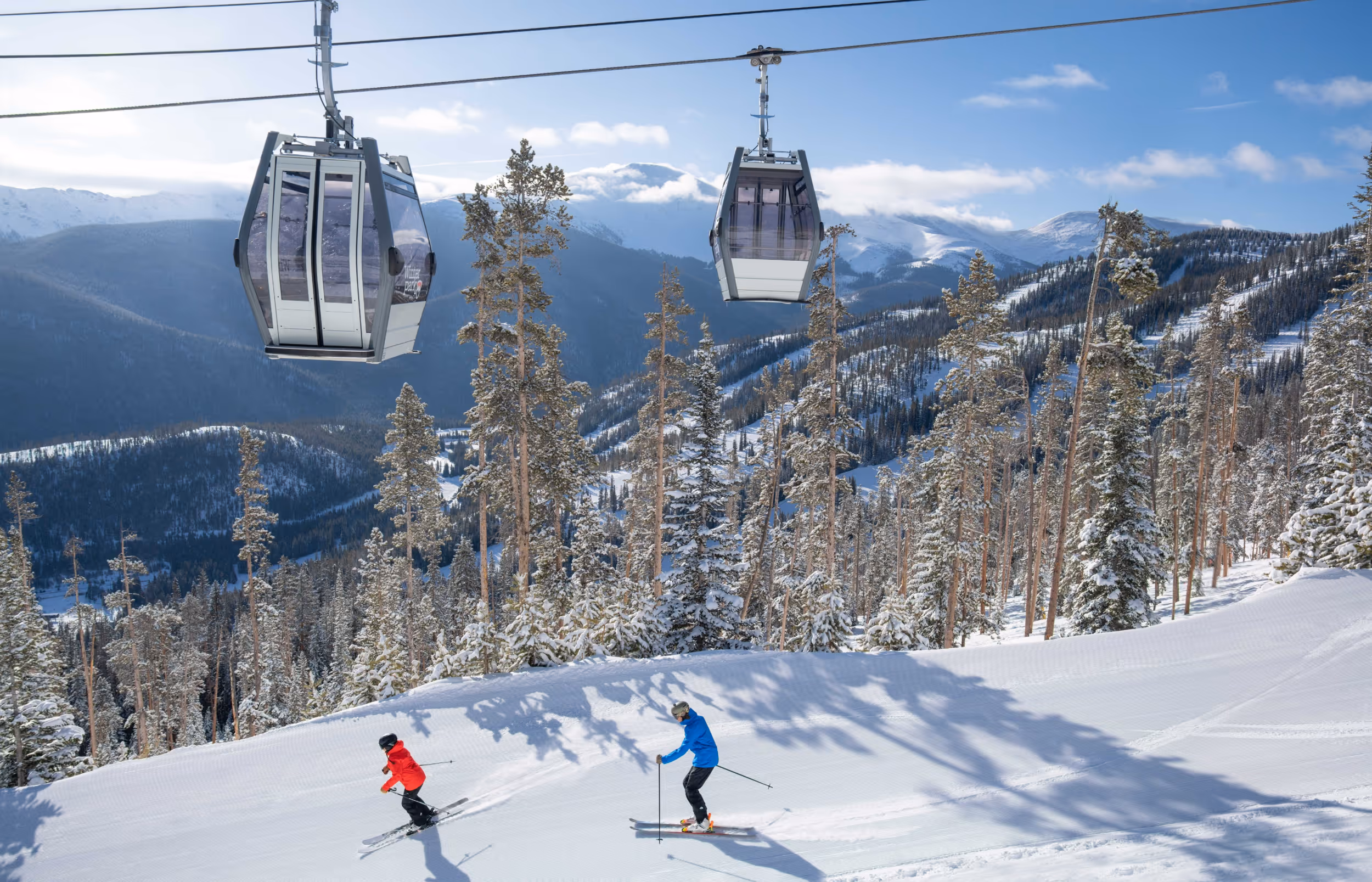 Some skiers crushing a groomer below the gondola at Winter Park 
