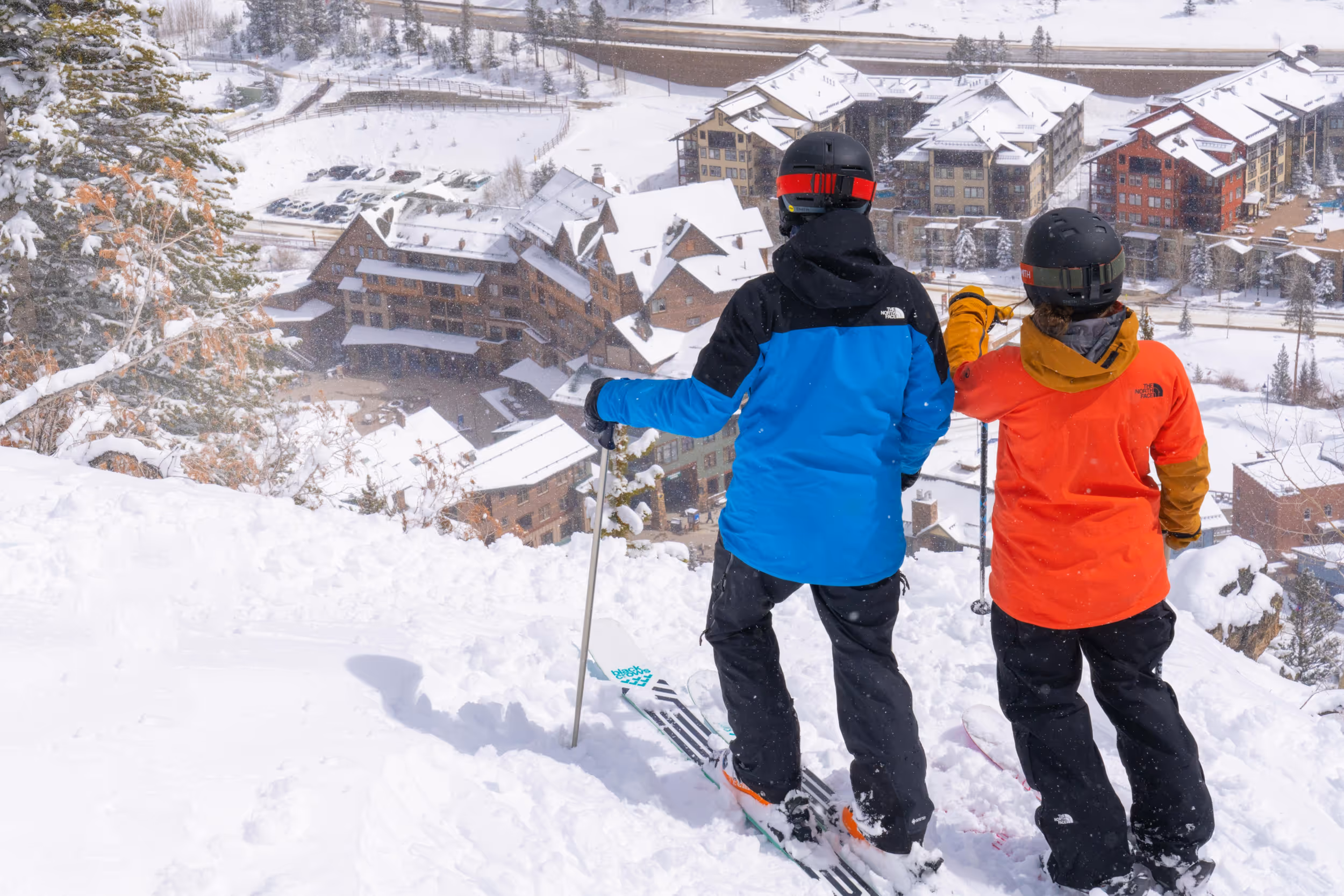 Some skiers looking at a steep pow run just above the base 