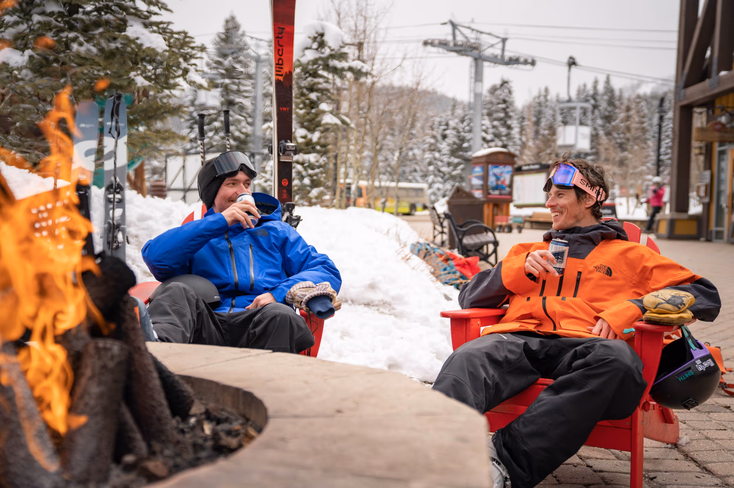 Some skiers enjoying a beer around the fire 