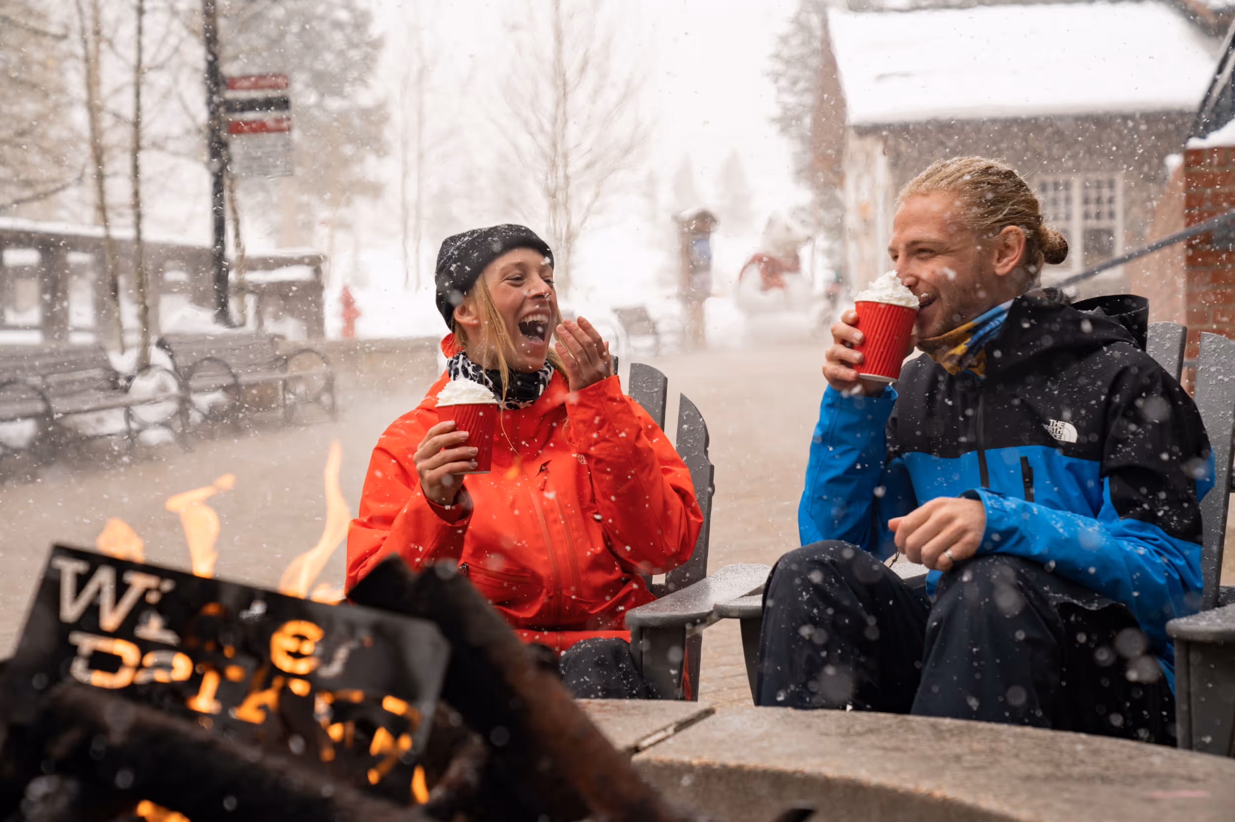 Some skiers enjoying some hot chocolate around a fire at Winter Park 