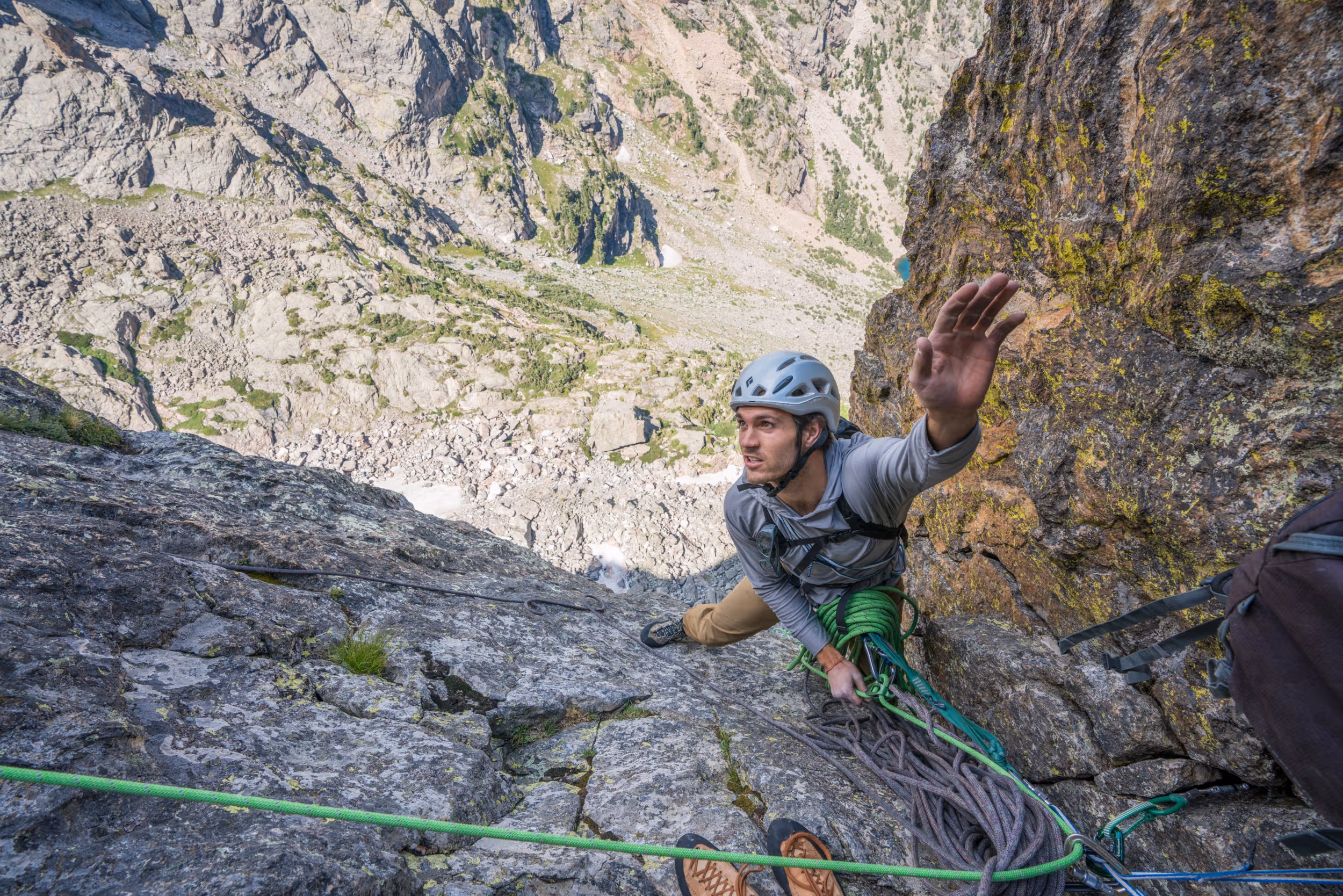 A climber reaching for his next hold