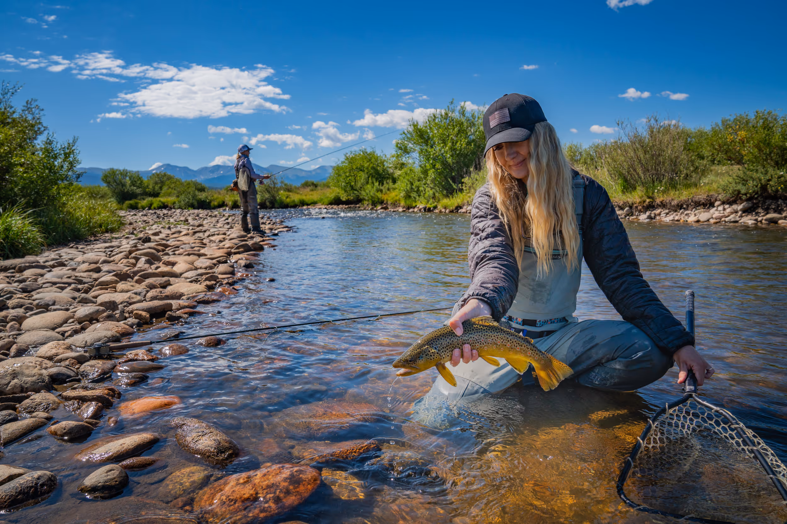 A proud fly fisher woman holding her catch 