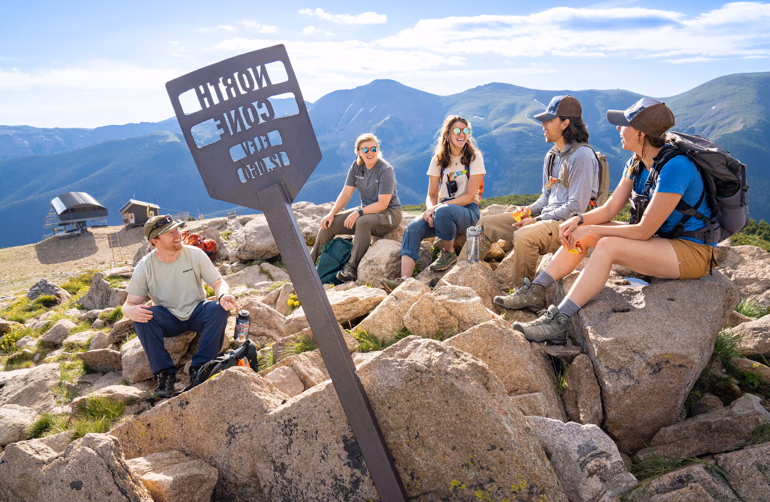 Some hikers taking a break at the top of a rocky peak 
